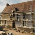 Maison ancienne en pierre sous échafaudage pendant des travaux d'isolation par l'extérieur